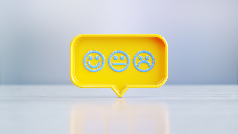 A yellow speech bubble with a happy face, neutral face, and sad face.