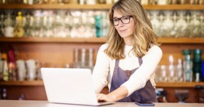 Woman sitting and looking at her laptop.