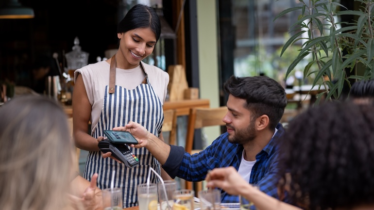 Man paying for his meal at a restaurant with his mobile device.