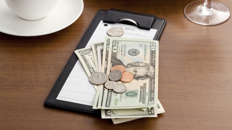 Bills and coins on a table.