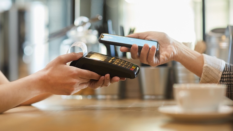 Customer paying for their order at a restaurant with their mobile device.