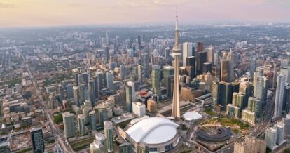 Aerial view of the city of Toronto, with the CN Tower and Rogers Centre stadium at sunset.